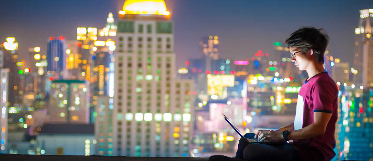 Man with laptop infront of city scape